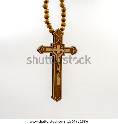 Wood rosary in white background. Light brown wooden beads.