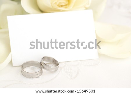 Blank paper with rings and rose, focus on rings.