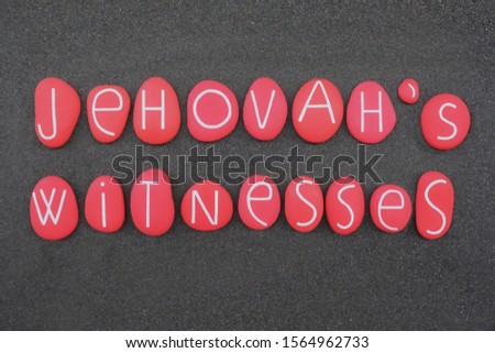 Jehovah's Witnesses, religion name composed with red and carved stone letters over black sand