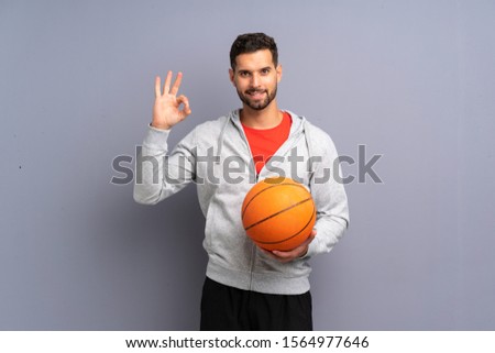 Handsome young basketball player man showing ok sign with fingers