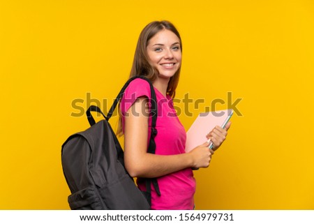 Young student girl over isolated yellow background with happy expression