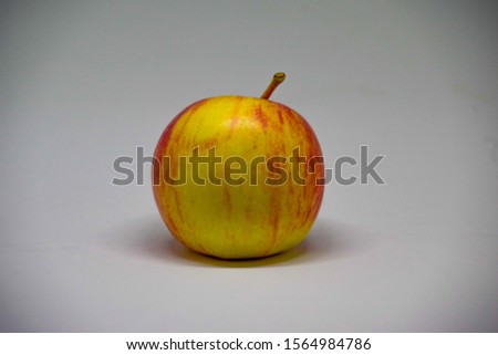 A single ripe apple on  a white back background