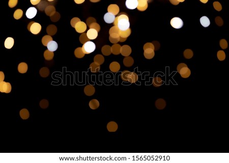 big yellow golden bokeh for background on black. Christmas lights.