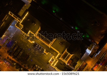 Aerial image night scene of Bustling life with people, cars, traffic and lights on buildings lit at night at a busy high street in Wulingyuan town at dusk