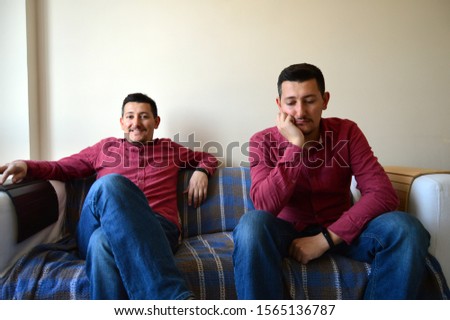 Sad and Happy (manic and depressive) Emotion of Same White Middle Aged Male Sitting on a Couch. Bipolar Man.  Royalty-Free Stock Photo #1565136787