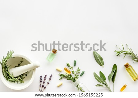 Apothecary of natural wellness and self-care. Herbs and medicine on white background top view frame copy space Royalty-Free Stock Photo #1565155225