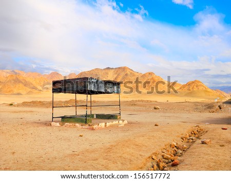 Amazing barren view with lonely Bus stop in desert of Ladakh against the background of distant mountain range and dramatic cloudy blue sky, Himalaya, Jammu & Kashmir, Northern India, Central Asia