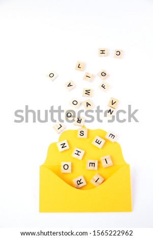 Text, message, letters scattered  in yellow envelope isolated on white background