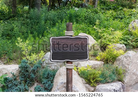 Wood sign direction or information board with unique shape in a park