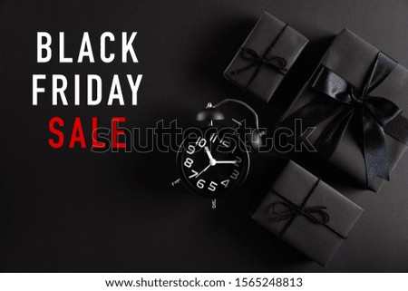 Top view of Black Friday Sale text with black gift box with Alarm clock on white background. Shopping concept boxing day and black Friday composition.