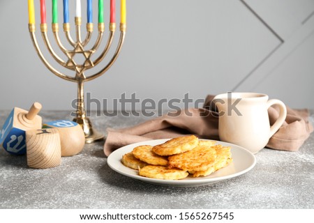 Menorah, potato pancakes and dreidels for Hanukkah on table