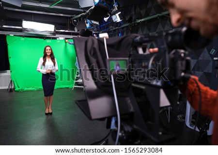 Presenter and video camera operator working in studio. News broadcasting