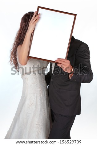 Bride and groom with a frame for photos