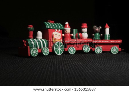 Red children`s Christmas train on a black background. New Year's toy.