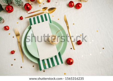 Christmas table setting. Holiday Decorations with vintage tree toys, shiny confetti, golden cutlery on light linen tablecloth with copy space. Holiday layout.
