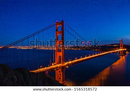 A view of the Golden Gate Bridge with the city of San Francisco skyline in the background and the bay.