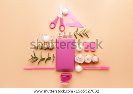 Beautiful Christmas tree made of stationery on color background