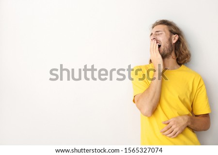 Portrait of tired man on light background