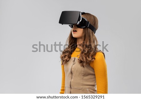 technology, augmented reality and entertainment concept - teenage girl with virtual headset or vr glasses over grey background