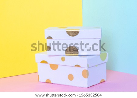 White gift box with a bow on a colorful pastel background. New year and birthday concept. Empty space for text.
