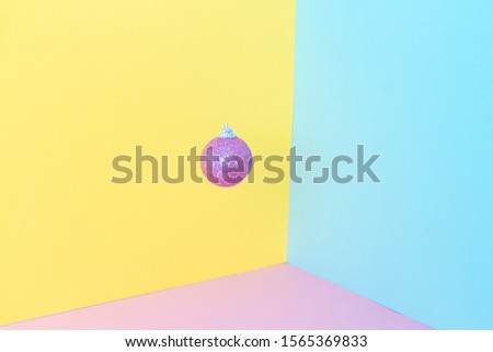 Pink frosted christmas ball on yellow,  and pink background. 3D composition. New year and birthday concept. Empty space for text.
