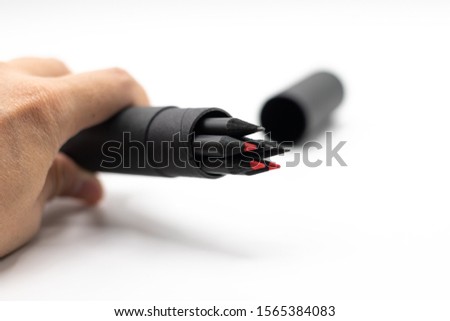 close up man hand holding the pencils black and red in mack up packaging on white background. for concept design 