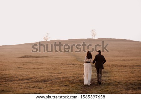 the bride and groom go into the distance. fog. morning. atmospheric photo. frame from the movie. cover of a novel