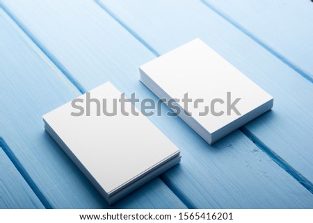 Business card blank on blue wooden background. Corporate Stationery, Branding Mock-up. Creative designer desk. Flat lay. Copy space for text