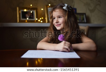 a little girl writes a letter to Santa Claus