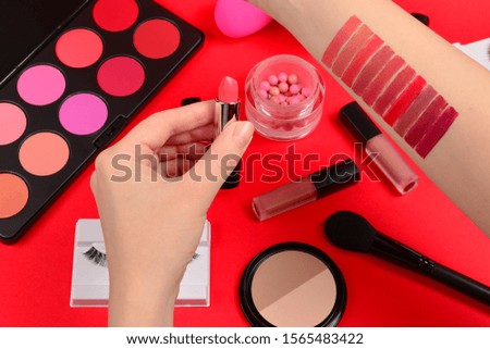 Lipstick swatches on woman hand. Professional makeup products with cosmetic beauty products, foundation, lipstick,  eye shadows, eye lashes, brushes and tools.