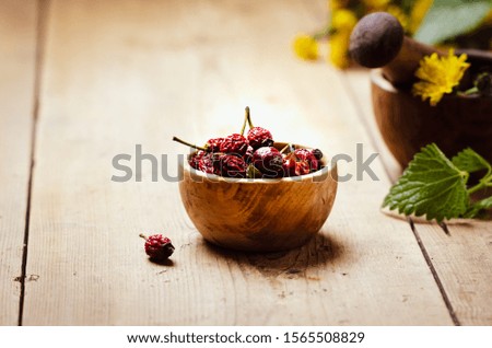  Dried rose hip for herbal tea in a wooden bowl. 