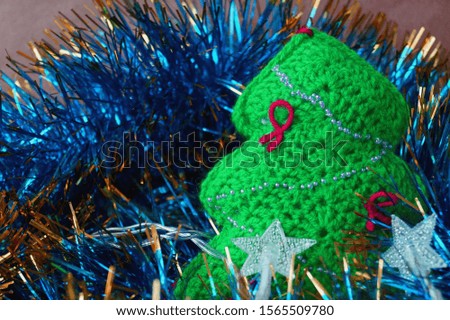 Crochet Christmas tree on a background of tinsel
