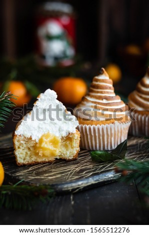 Citrus cupcakes with lemon curls and a hat from Swiss meringue. Dessert on the New Year's table.