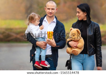 Happy family in autumn forest. Happy child laughing and smiling. Sunny autumn forest, sun beam.