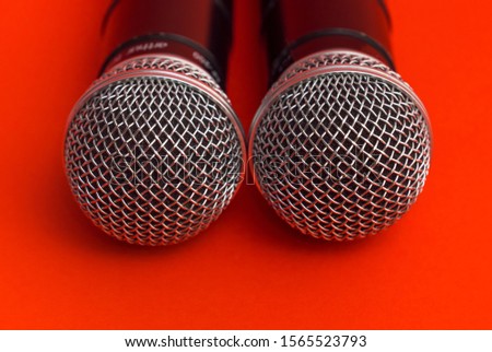 Two karaoke microphone on a red background