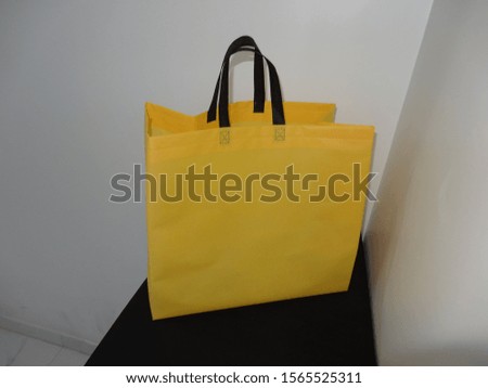 Beautiful Yellow Color Non woven Bag Stand on Black Table