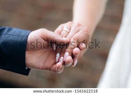 Man is holding a woman's hand with tender pink manicure outdoors