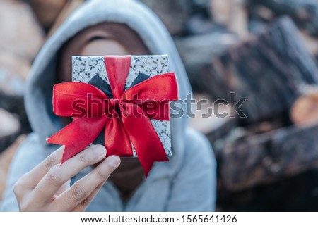 Gift box with red ribbon in woman's hand. Vintage tone picture. Selective focus.