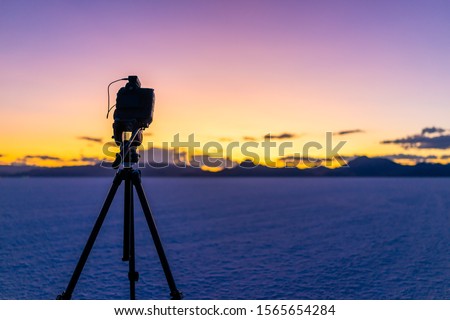 Bonneville Salt Flats near Salt Lake City, Utah at colorful twilight after sunset with purple sky and tripod with camera doing time lapse photography