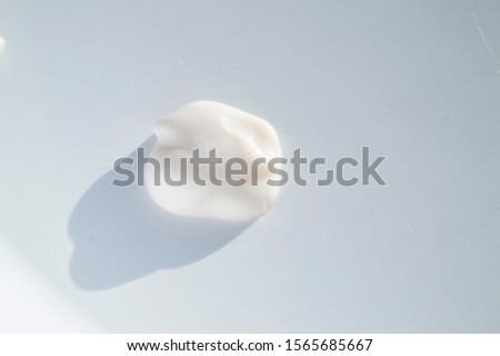 A drop of cream for body care, close-up detail of the beauty cream isolated on white background in bright sunlight Royalty-Free Stock Photo #1565685667