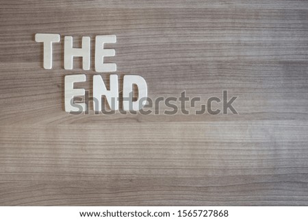 The End words with wood letters over wood background