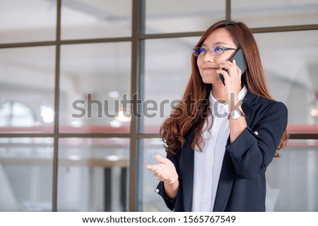 Closeup image of a businesswoman holding and talking on mobile phone