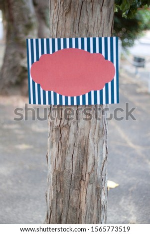 Mock up of colourful sign attached to a tree
