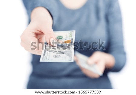 Woman hand giving paper money, shallow depth of field, isolated on white background. Front view. Counting or spend money.