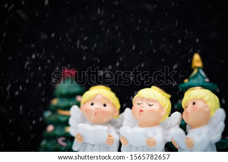 Christmas caroling or Carolers singing on black background.Angel group singing carol song on celebration of christmas season in winter time.Chorus singing, Worship, and Sing a song in winter concept.