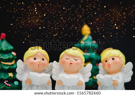 Christmas caroling or Carolers singing on black background.Angel group singing carol song on celebration of christmas season in winter time.Chorus singing, Worship, and Sing a song in winter concept.