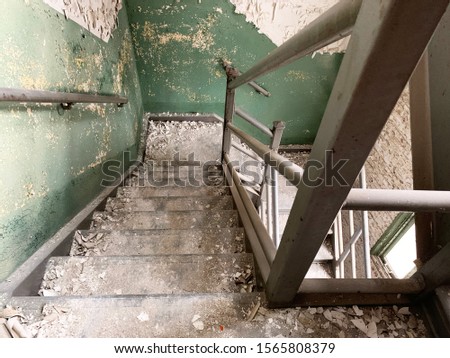 Old abandoned factory stairwell with peeling paint.