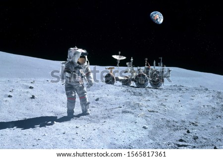 Astronaut near the moon rover on the moon. With land on the horizon. Elements of this image were furnished by NASA. Royalty-Free Stock Photo #1565817361