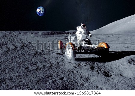 Astronaut near the moon rover on the moon. With land on the horizon. Elements of this image were furnished by NASA. Royalty-Free Stock Photo #1565817364