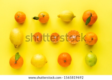Fresh oranges, tangerines and lemons seen from above on yellow background. Citrics. Healthy food. Knolling concept